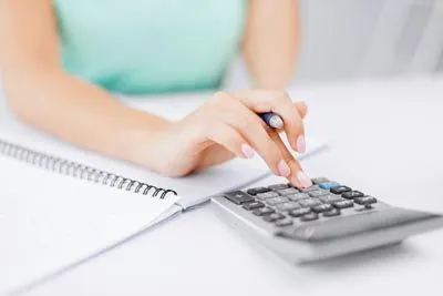 woman going through her finances using a calculator